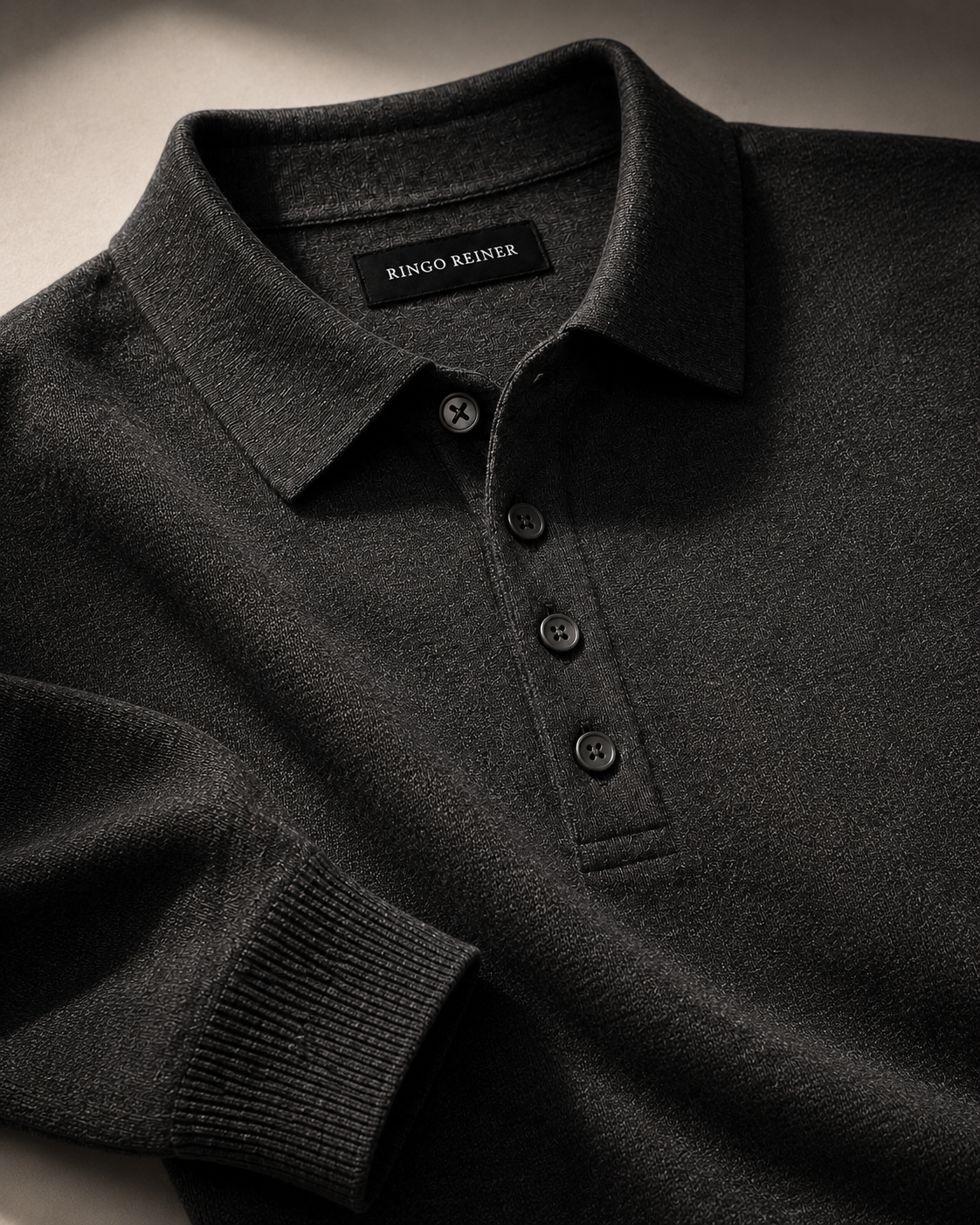Close-up of the Ringo Reiner Pilot’s Knit showing the structured collar, button placket, fine-knit texture and ribbed cuff in charcoal